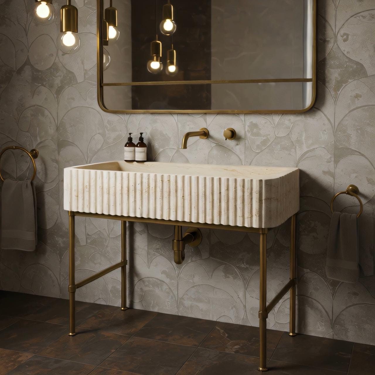 Sleek hand-carved beige travertine console sink with fluted detailing and brass metal base.