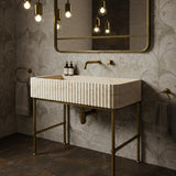Beige travertine fluted console sink crafted from hand-carved stone with elegant brass metal stand.