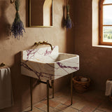 Calacatta Amber Viola marble vanity with brass legs and integrated stone backsplash.