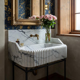 A fluted Calacatta Viola marble console sink with high back and side splashes, designed for elegant, heritage-inspired bathrooms.