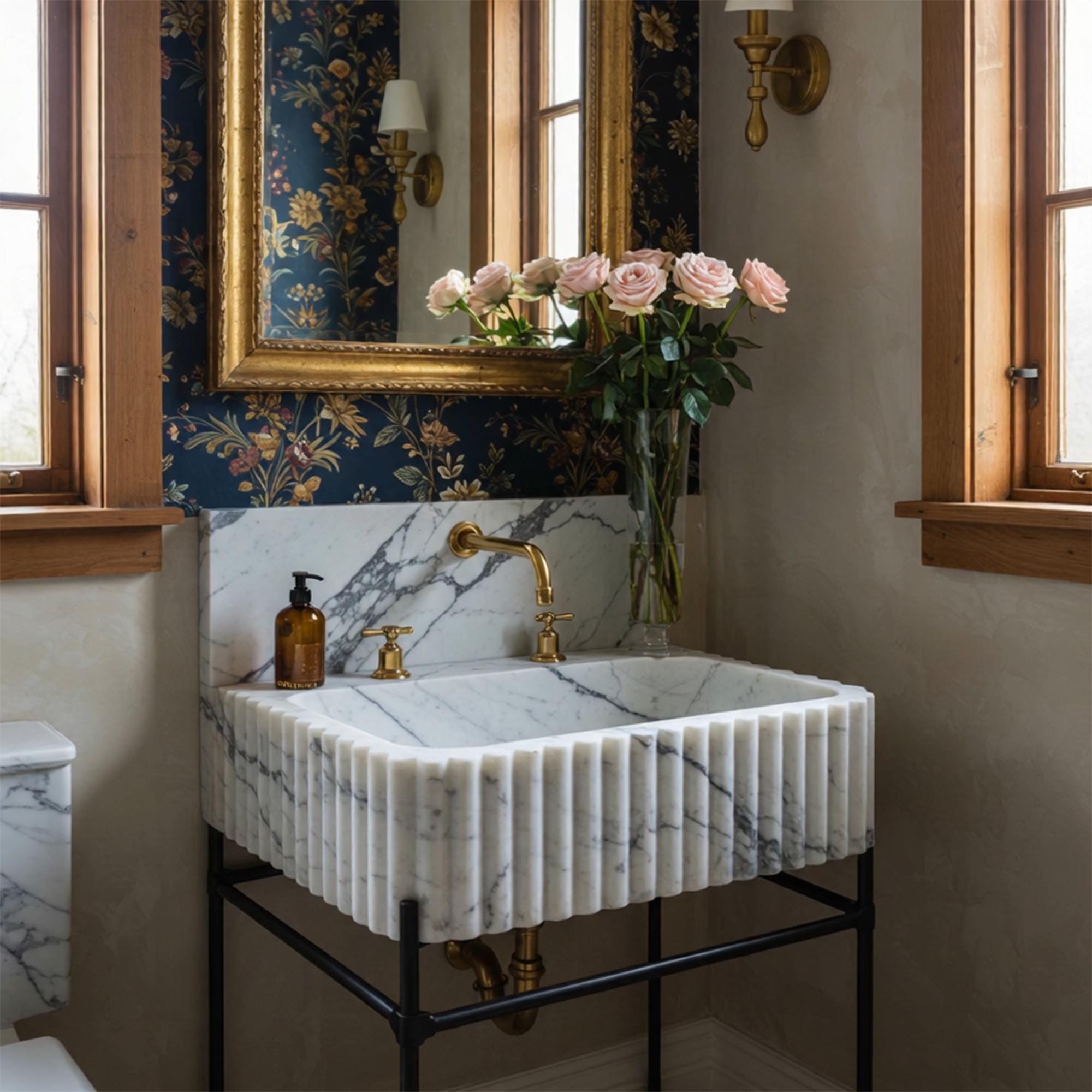 This fluted marble sink in Calacatta Viola rests on a matte black metal base, made to elevate any refined interior.