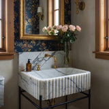 A striking Calacatta Viola fluted marble sink with a black metal stand, crafted for luxurious powder rooms.