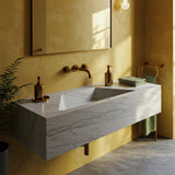 Carrara marble extra wide floating sink with minimalist wall-mounted design and brass accents.
