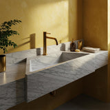 Carrara marble floating vanity sink with integrated backsplash and hand-carved stone design.