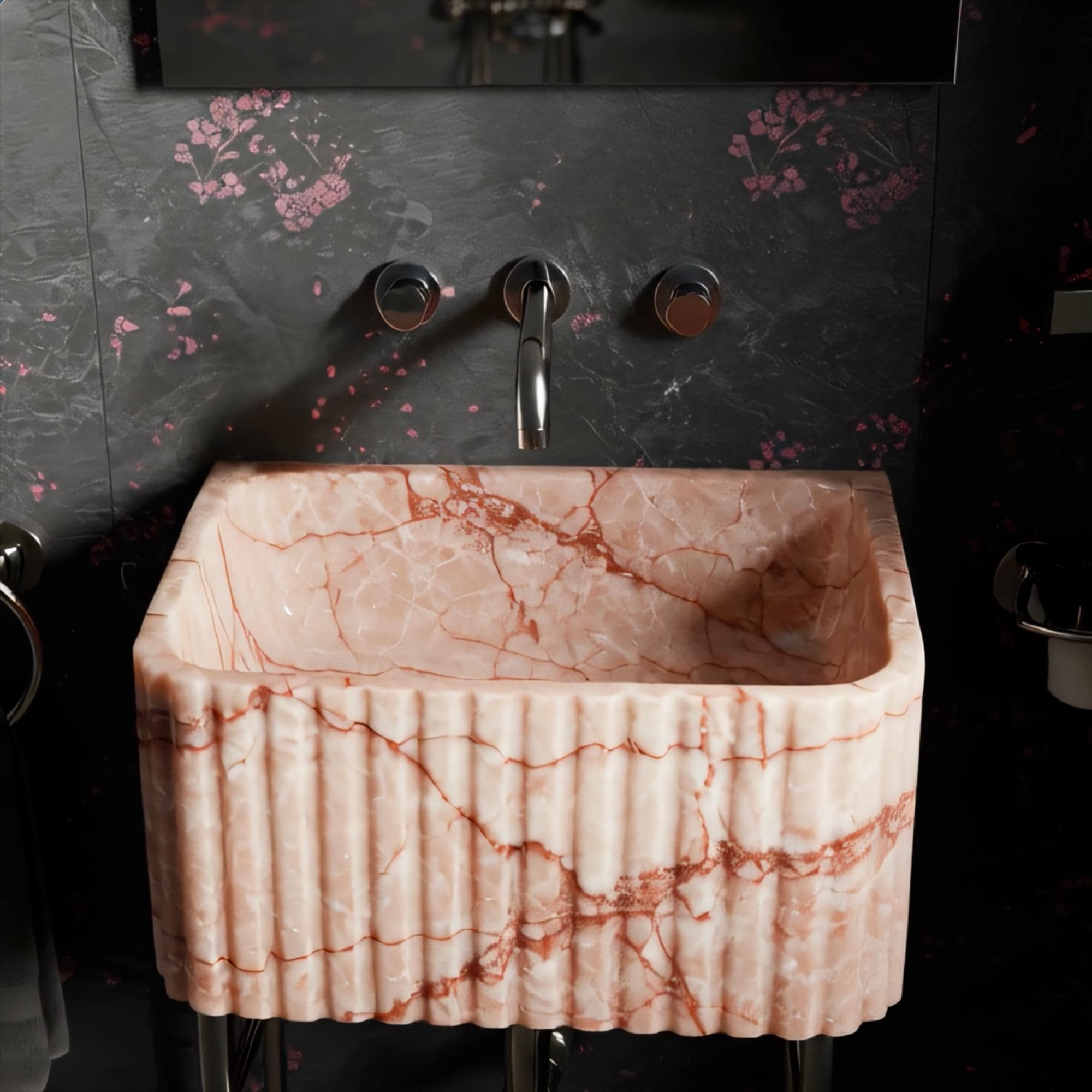 Sculptural pink marble basin with vertical fluting and minimalist metal frame.
