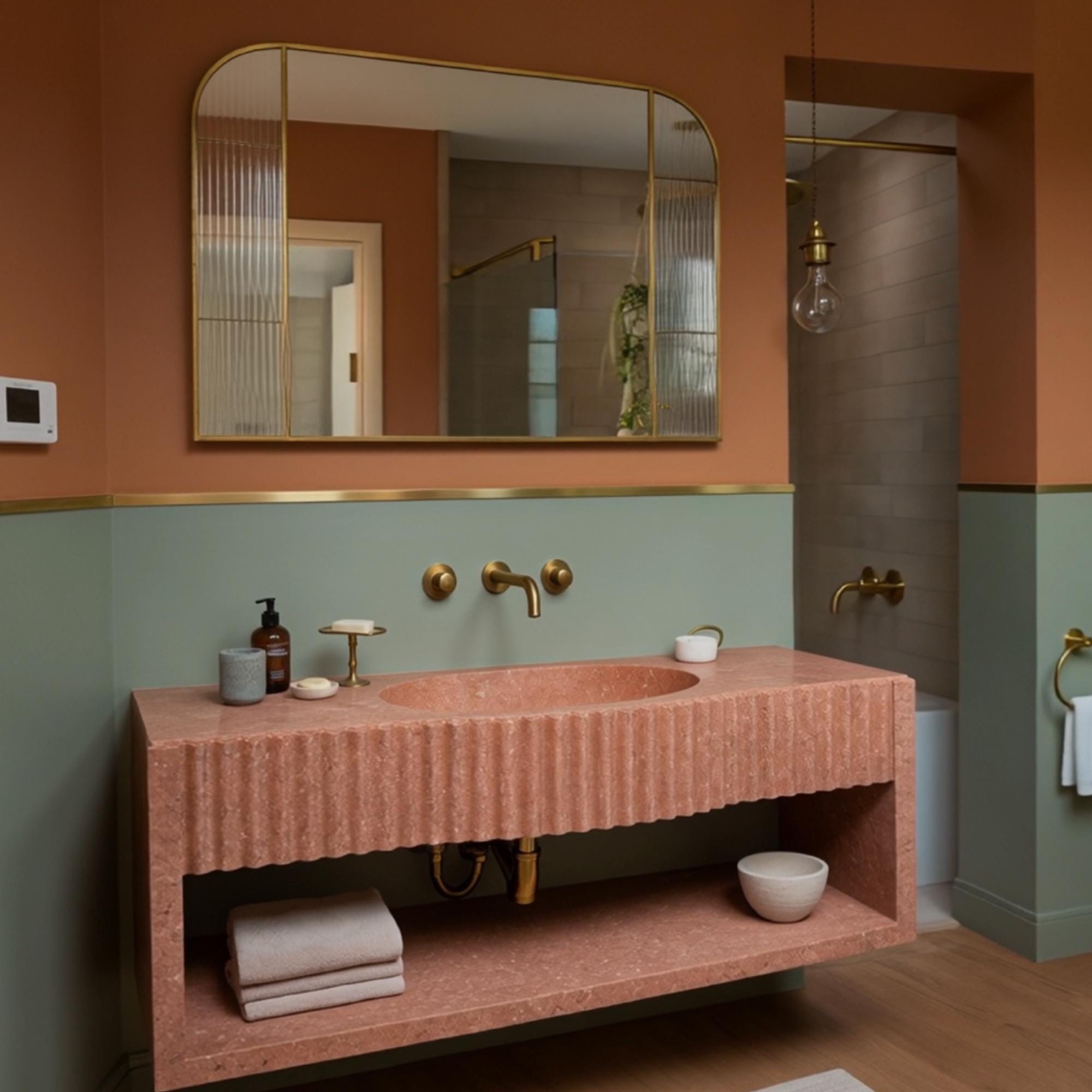 Fluted red travertine bathroom sink with oval basin and wall-mounted vanity shelf for minimalist storage.