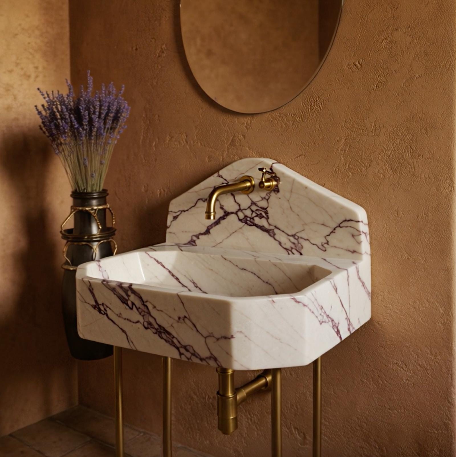 Striking marble sink in Calacatta Viola with distinctive peaked backsplash and warm brass fixtures.