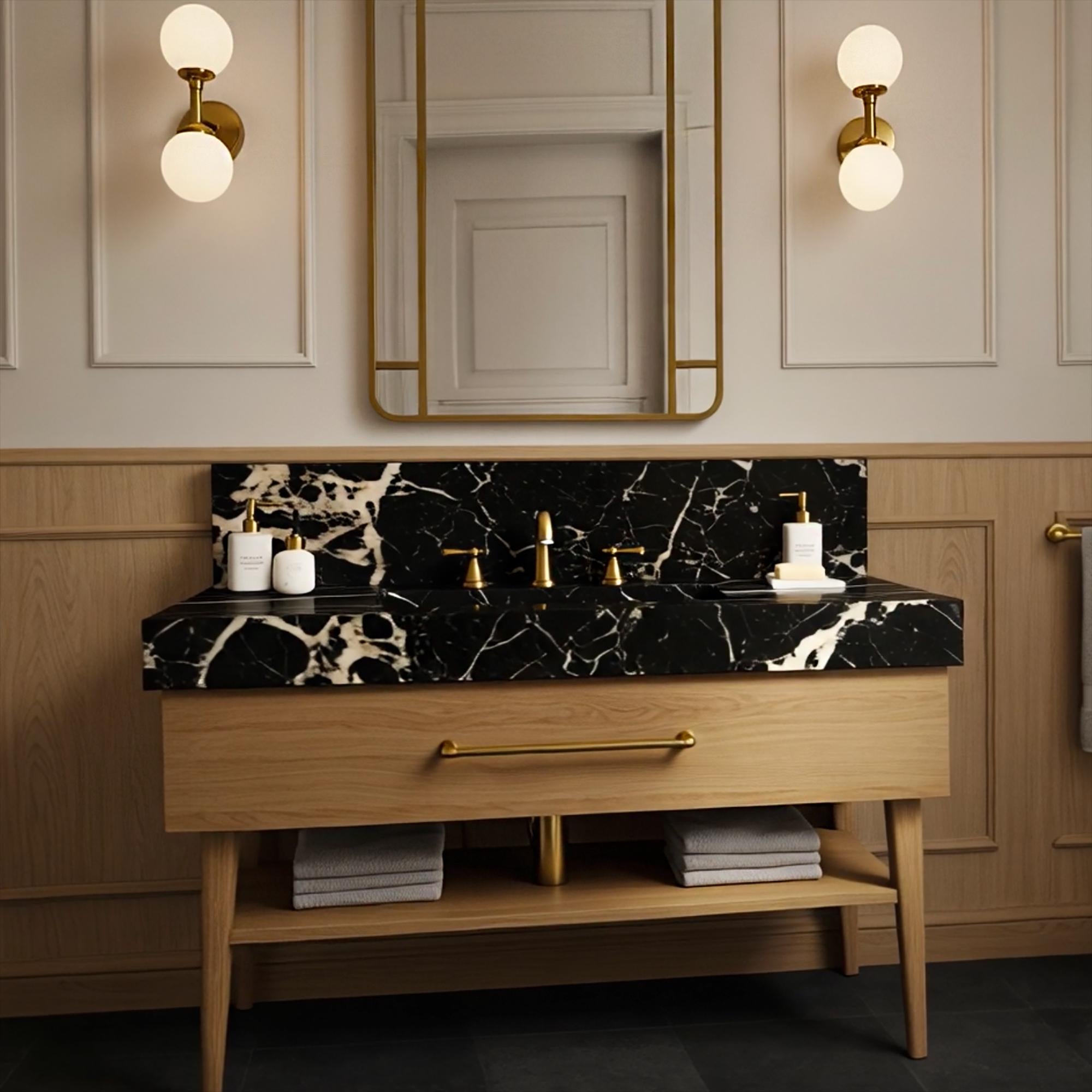 Natural oak console vanity with bold black marble sink top and polished brass handle detail.