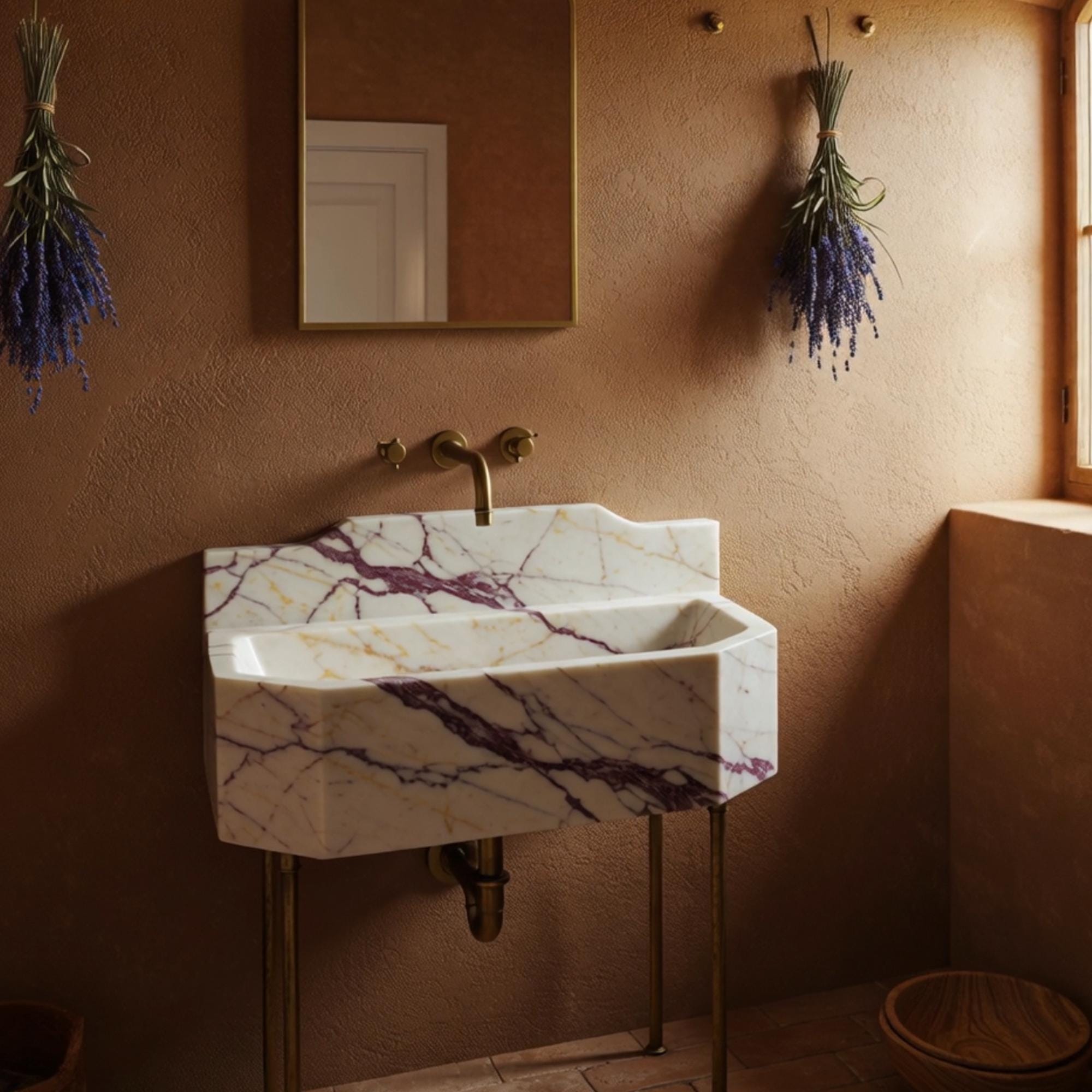 Octagonal bathroom sink in Calacatta Amber Viola marble with brass stand and sculpted backsplash.