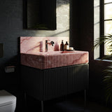 A soft pink fluted marble sink paired with a striking black ribbed cabinet for a bold yet elegant bathroom statement.