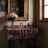 A scalloped console sink in deep Rosso Levanto marble with an integrated backsplash, designed for richly layered interiors.